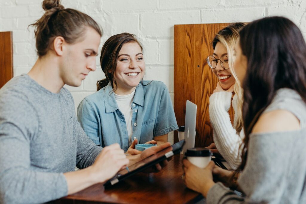Grupo de amigos conversando alrededor de una mesa de cafetería