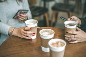 Taza de café junto a un teléfono móvil
