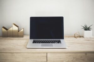 Portátil, cuaderno y taza de café sobre un escritorio